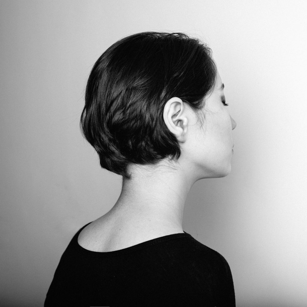 Person reaching to hold the side of their neck where it feels tight and sore