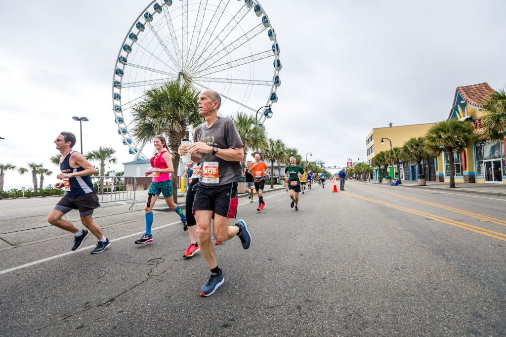 Runner in mid-stride during a race, hip and knee driving forward