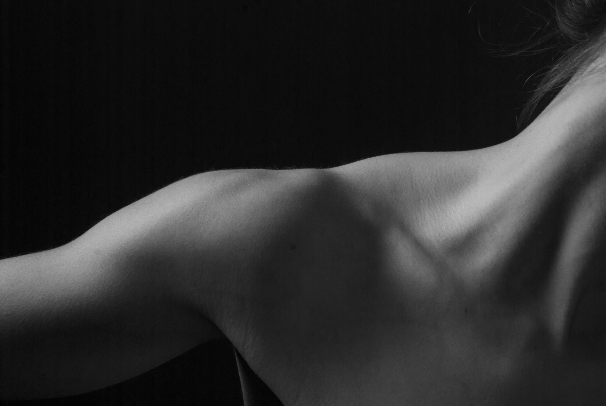 Person's neck and shoulders from behind, showing the upper back and base of the neck