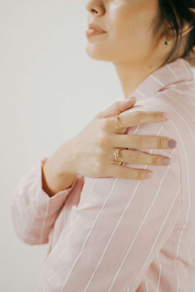 Person holding their upper arm and shoulder, guarding a painful area