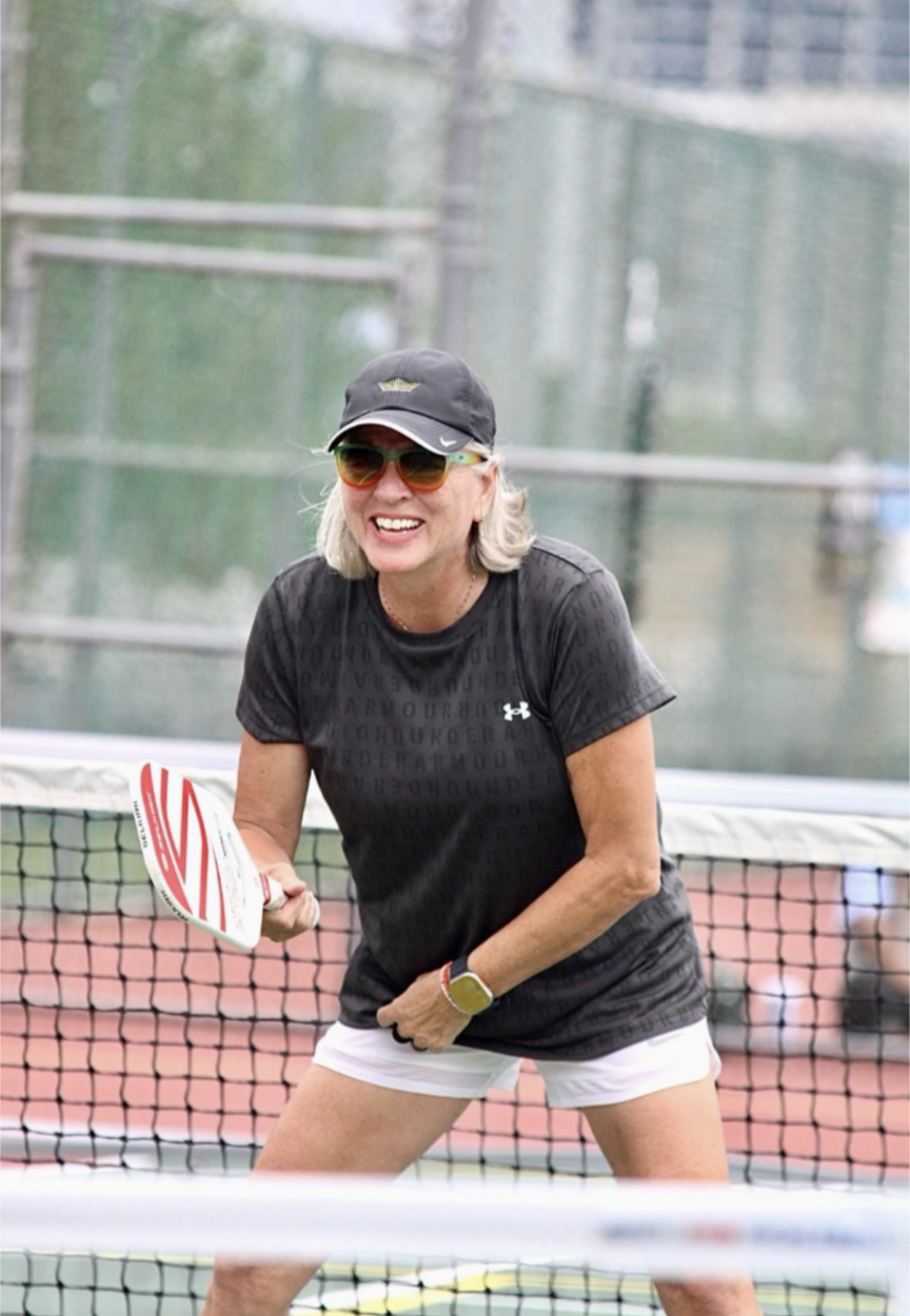 Pickleball player on the court with paddle raised, ready to return