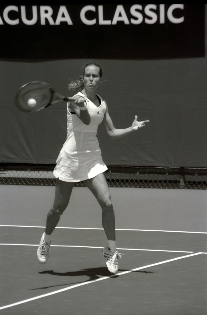 Tennis player hitting a forehand, arm extended at the point of contact
