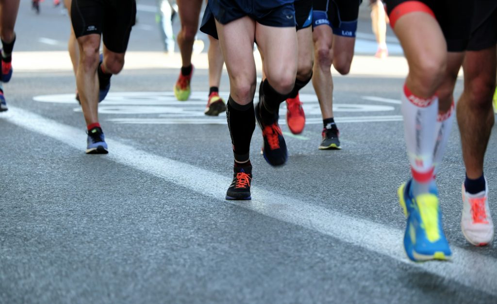 Runners' legs from the waist down during a road race