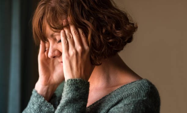 Woman holding her head with a tension headache
